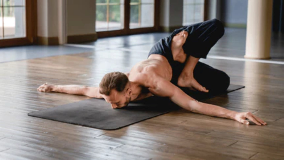  Individual demonstrating an advanced yoga pose on a mat, emphasizing flexibility and balance in a studio environment.