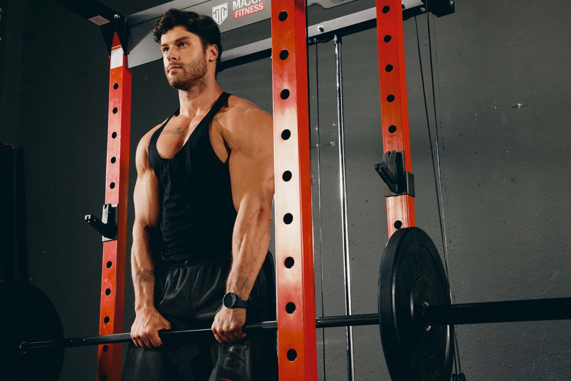 A man performing a deadlift with a barbell in a home gym setup.