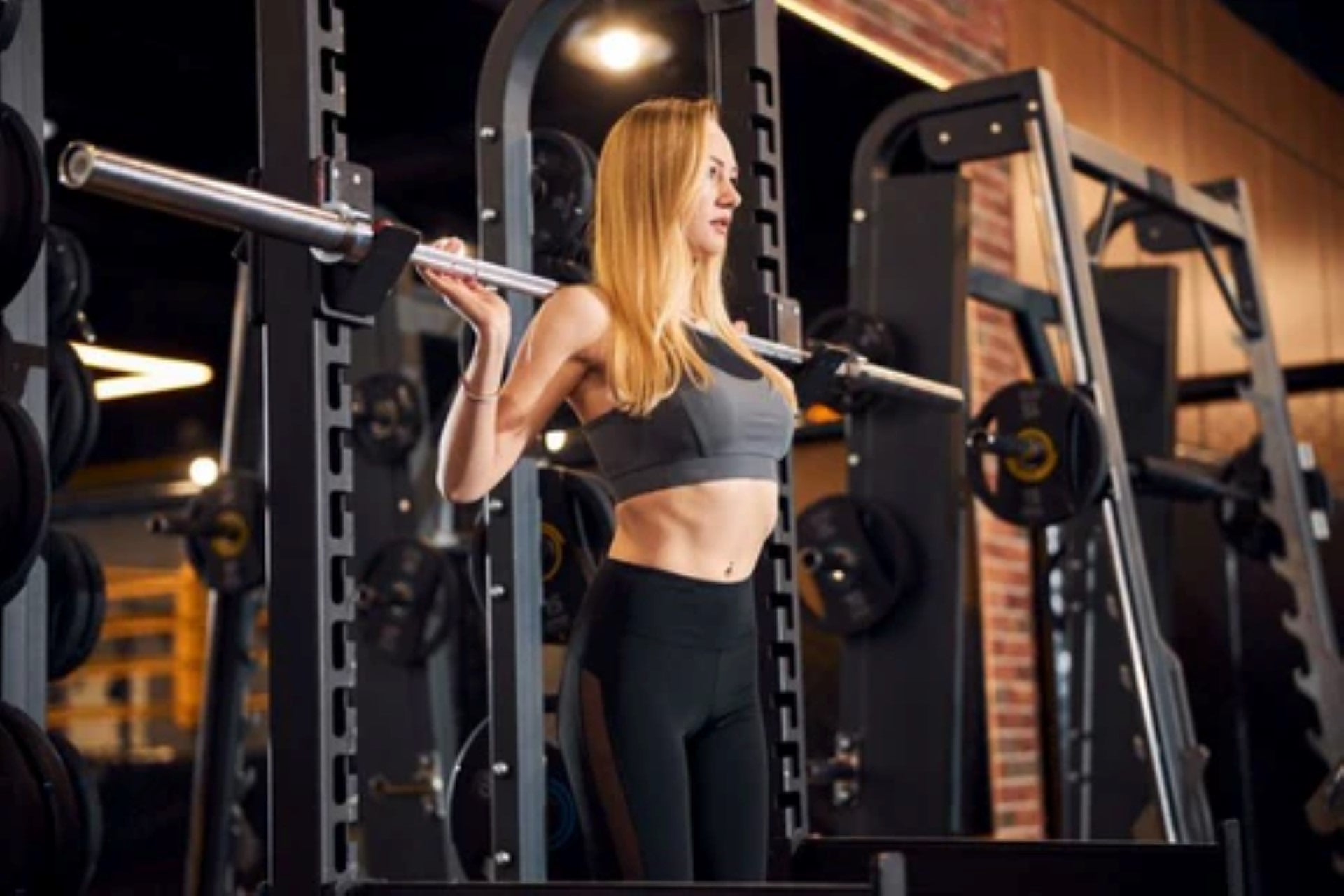 Woman practicing barbell squats in a power rack during a gym workout.