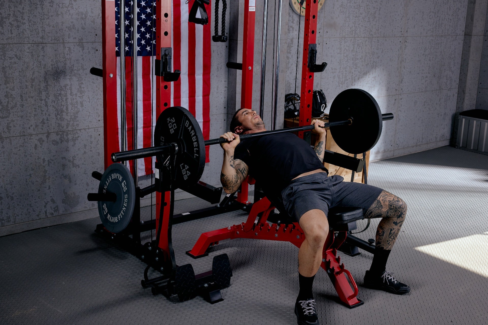 Person using a barbell for bench press exercises in a home gym environment.