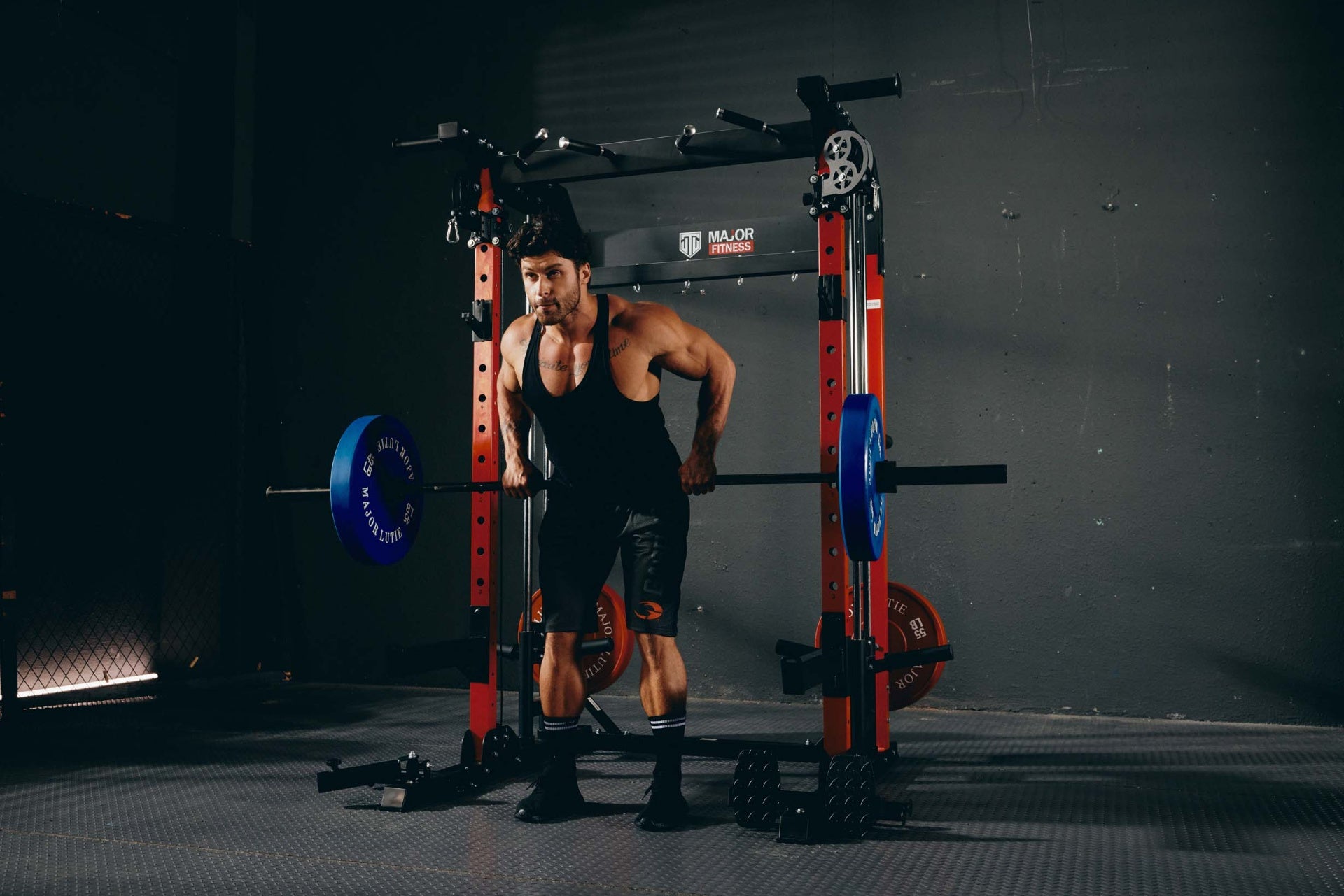 Man performing bent-over rows with a Smith machine in a home gym.