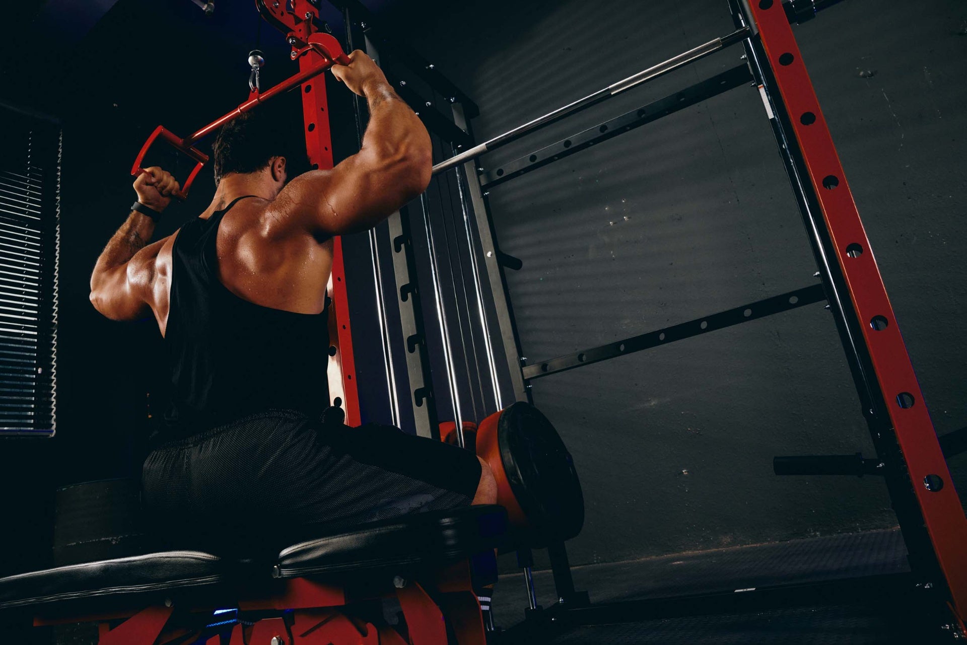 Man performing a tricep pushdown exercise using a cable machine in a home gym.