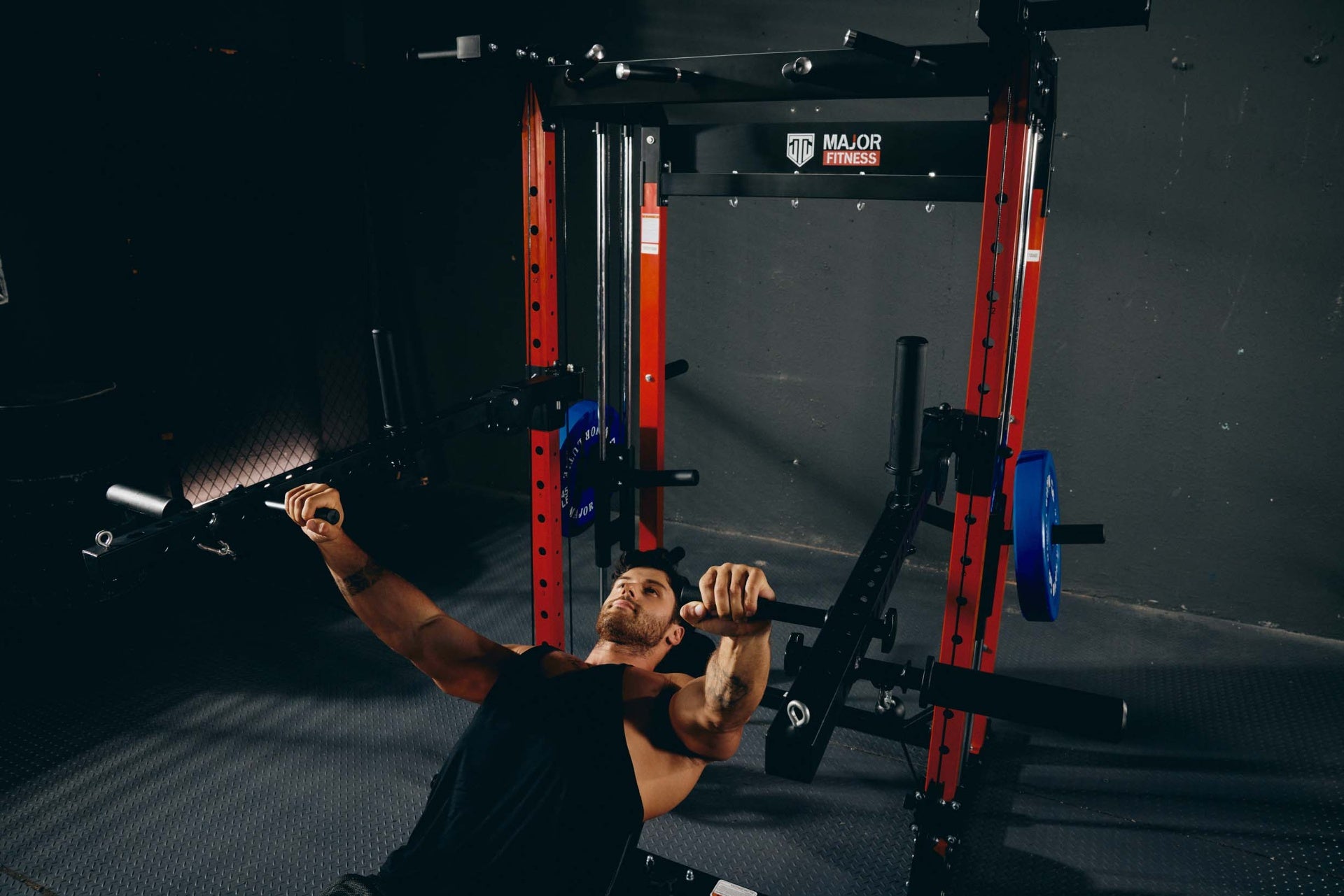 Strength training chest press on a power rack in a home gym.