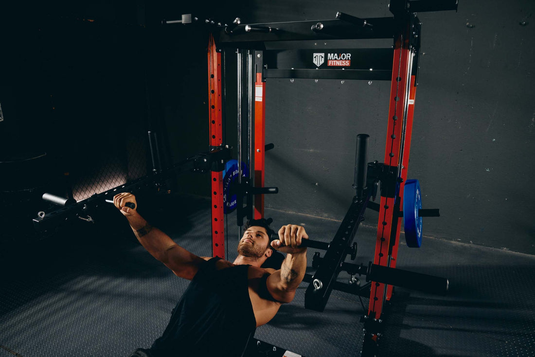 Man performing a chest press exercise using a power rack in a gym.