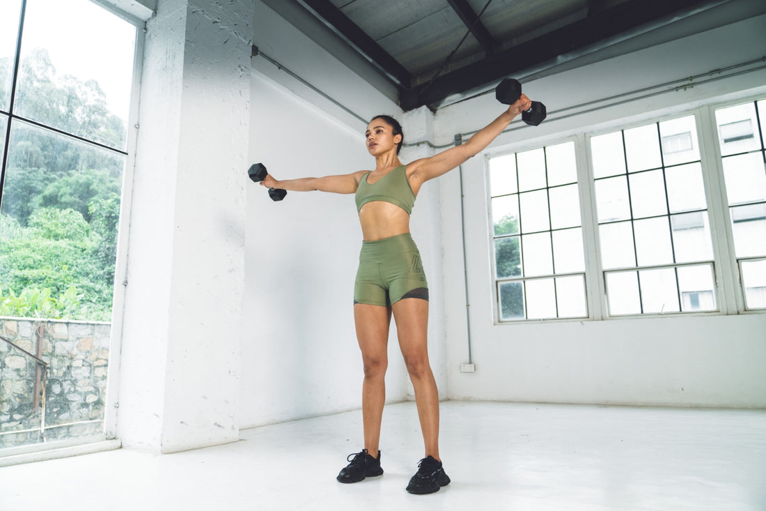 Woman working out with dumbbells in a home gym setting.