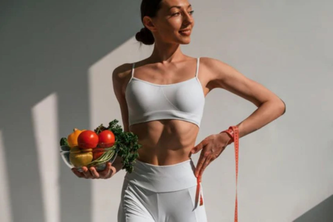 Fit woman showcasing a healthy lifestyle with fresh vegetables and a measuring tape.