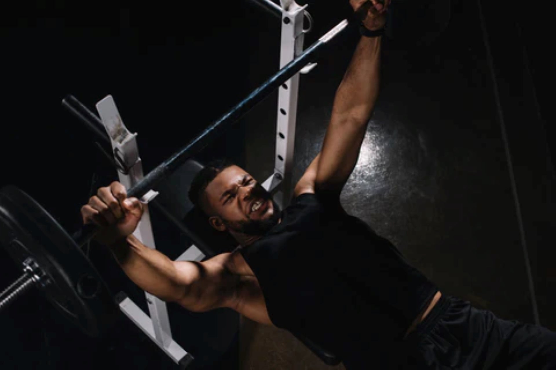 an athlete focused on lifting a barbell during an intense bench press workout