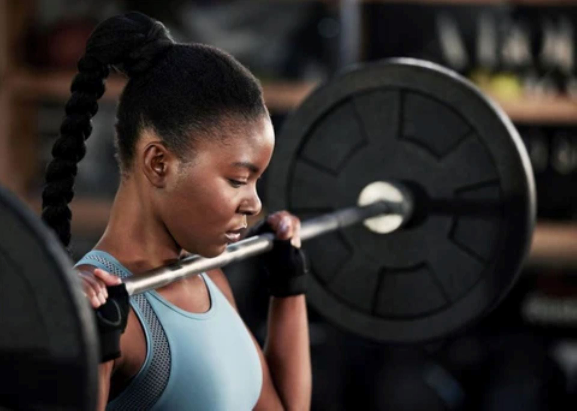 woman performing barbell squat in home gym for strength training