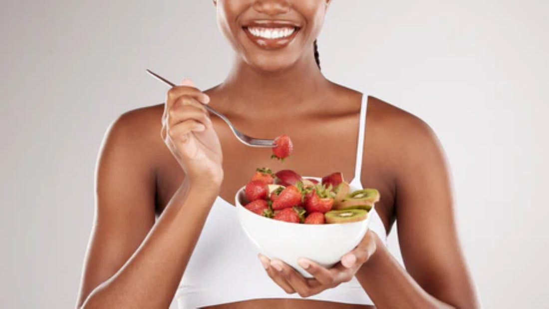 Woman enjoying a healthy fruit salad for post-workout nutrition.