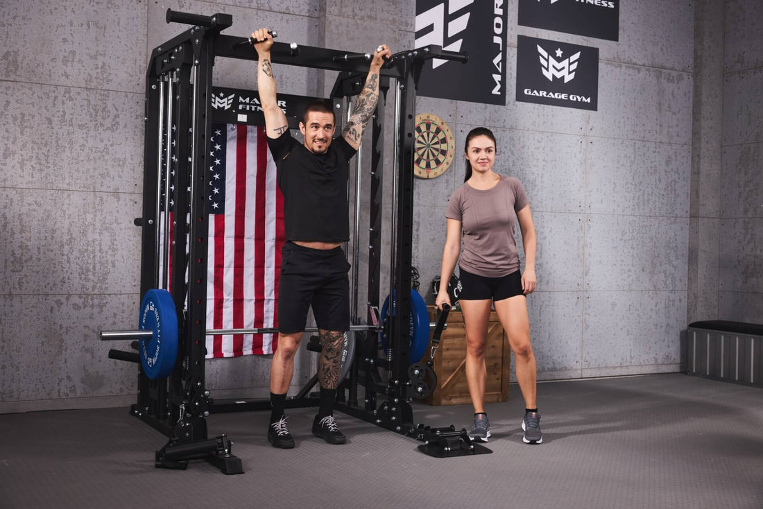 Man performing a pull-up on a Smith machine while a woman stands next to him in a home gym.