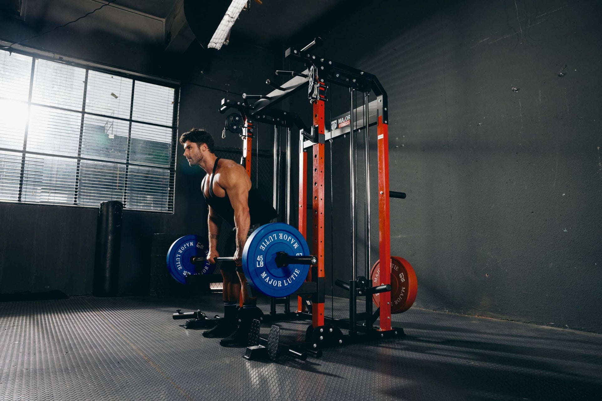 Man performing a deadlift exercise in a home gym using Major Fitness equipment.