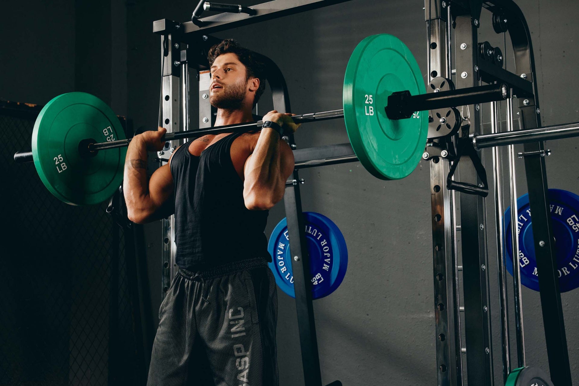 Man performing a front squat on a Smith machine in a home gym.