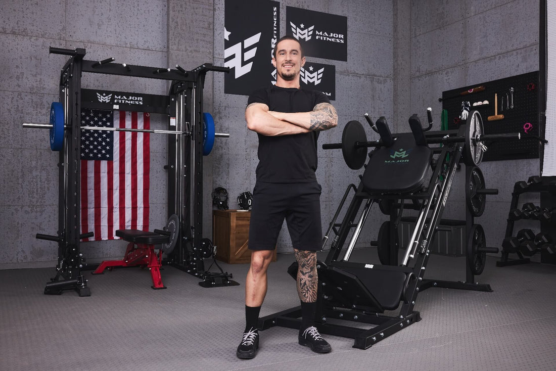 Trainer posing in a home gym equipped with a power rack and leg press machine.