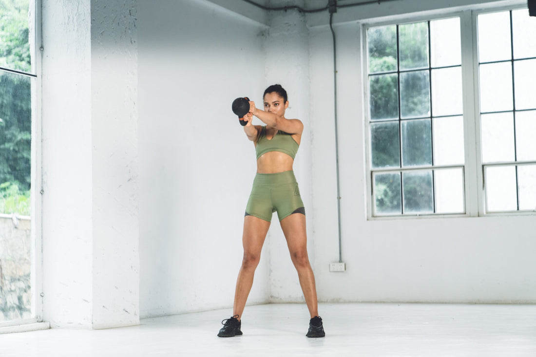 Woman performing a kettlebell workout in a home gym.