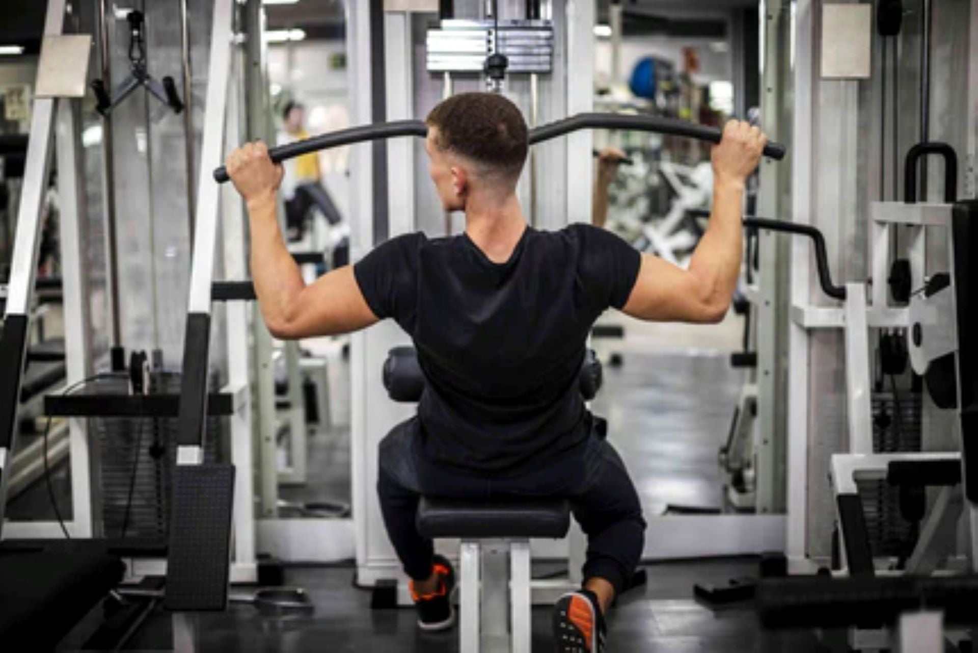 Man engaged in a back workout, using a lat pulldown machine for muscle building.