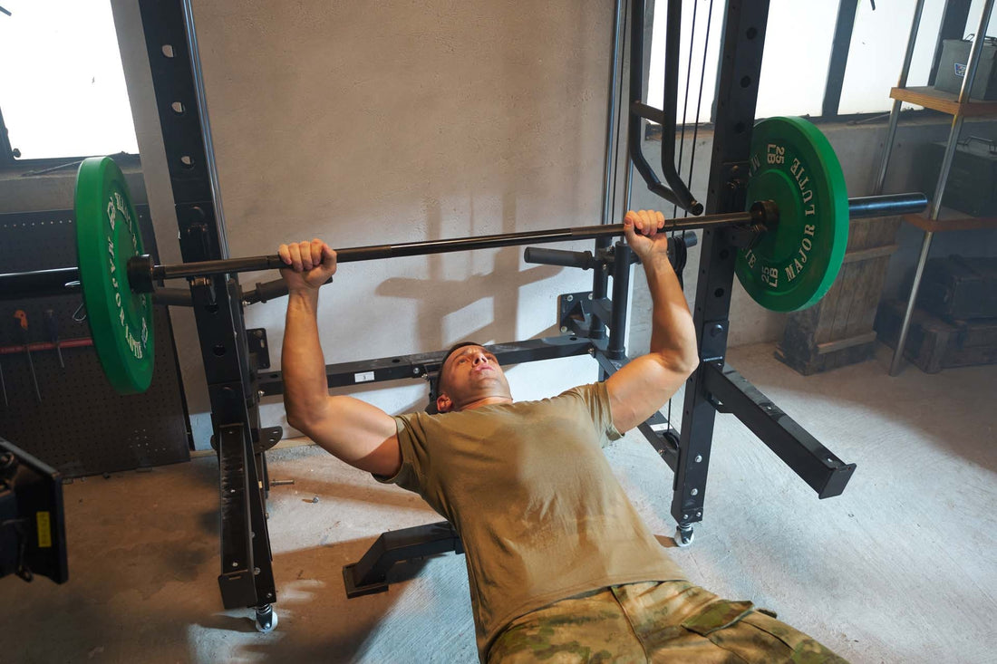 Man engaged in fitness training, performing a bench press with a barbell and green weight plates.