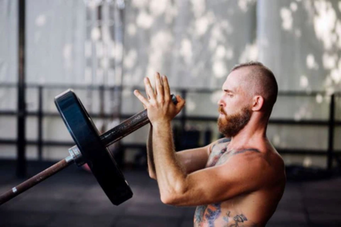 Individual engaged in a landmine press for upper body strength training.