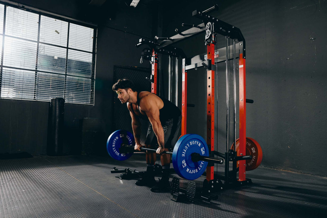 A man performing a barbell deadlift exercise in a home gym with a power rack.