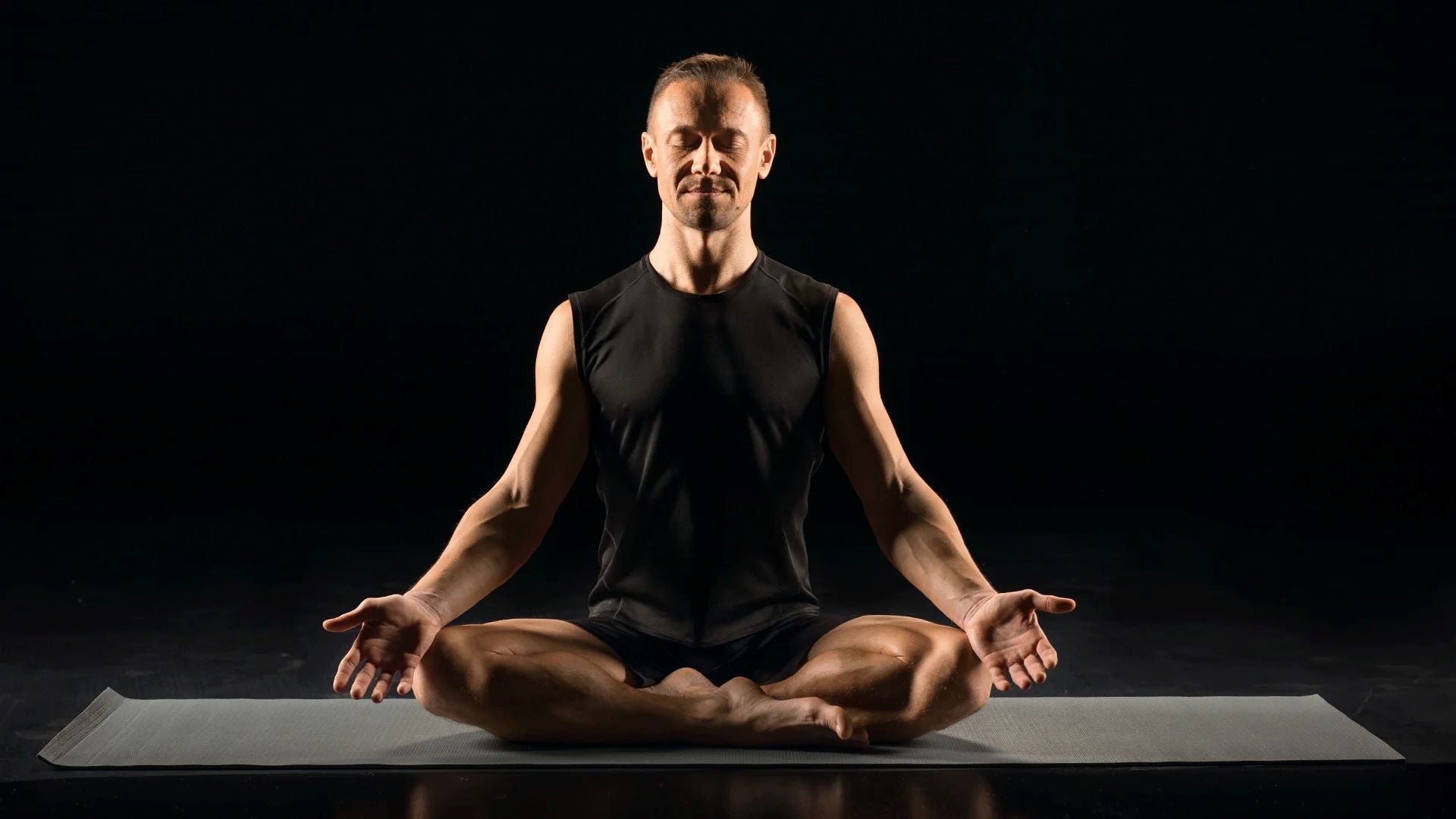 A man practicing meditation in a seated position on a yoga mat, focusing on mindfulness and mental clarity in a calm environment.