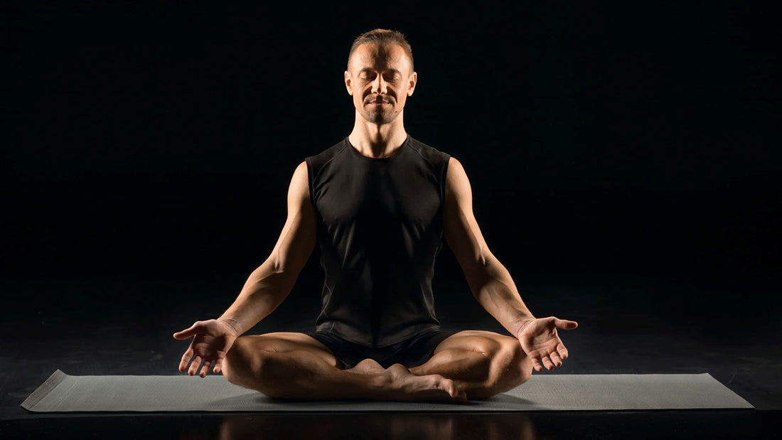 A man practicing meditation in a seated position on a yoga mat, focusing on mindfulness and mental clarity in a calm environment.