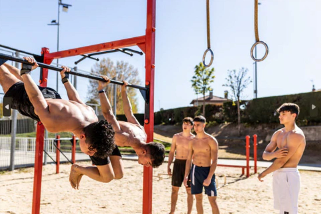 A group of men performing calisthenics exercises on an outdoor pull-up bar.