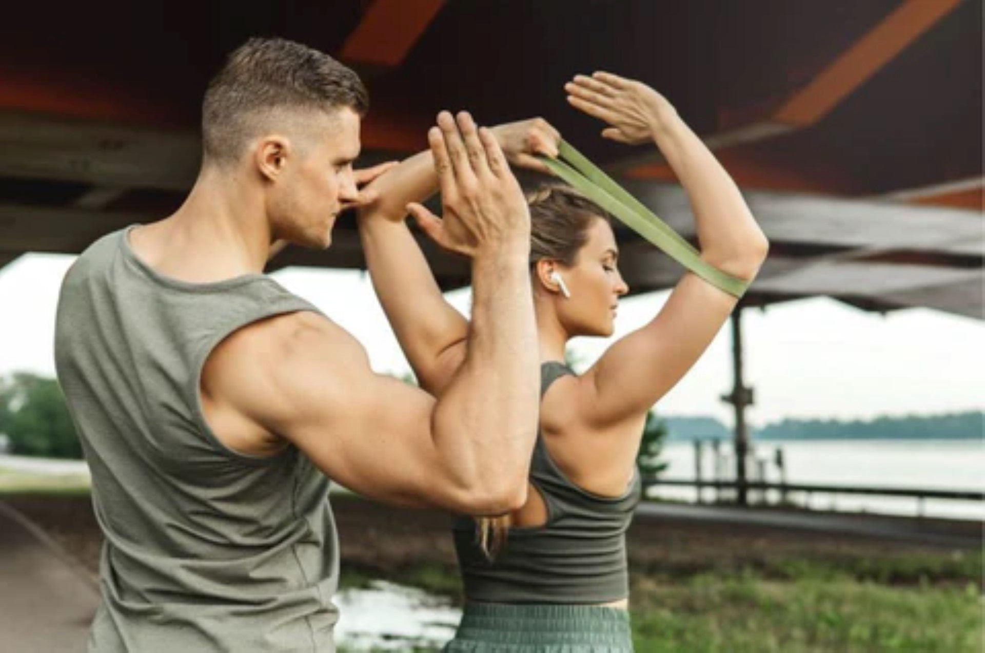 Couple engaged in resistance training with bands during an outdoor workout.