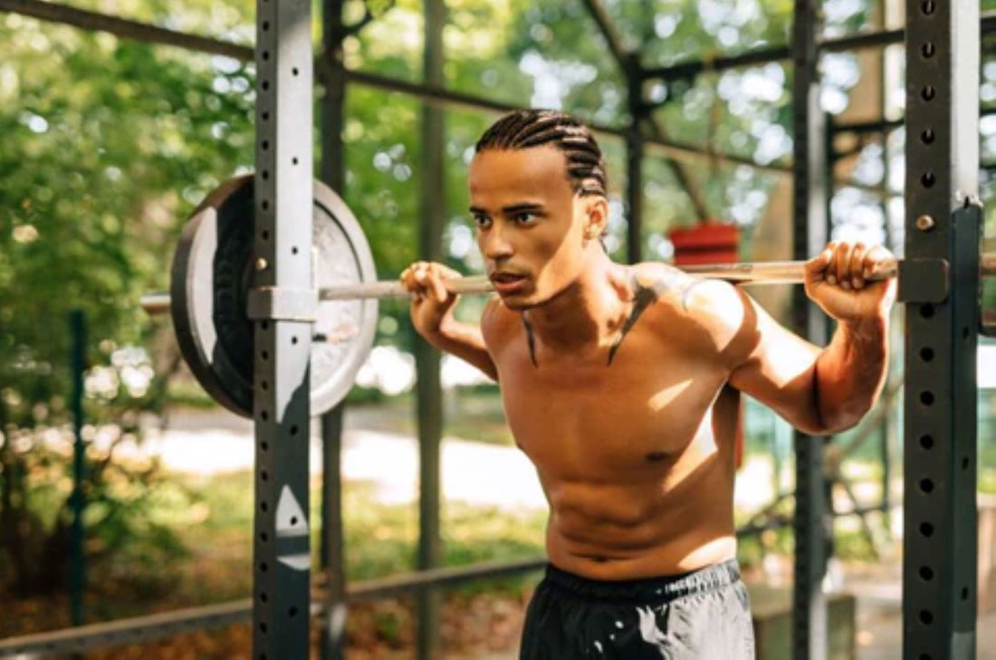 Fitness enthusiast doing barbell squats in an outdoor power rack setup.