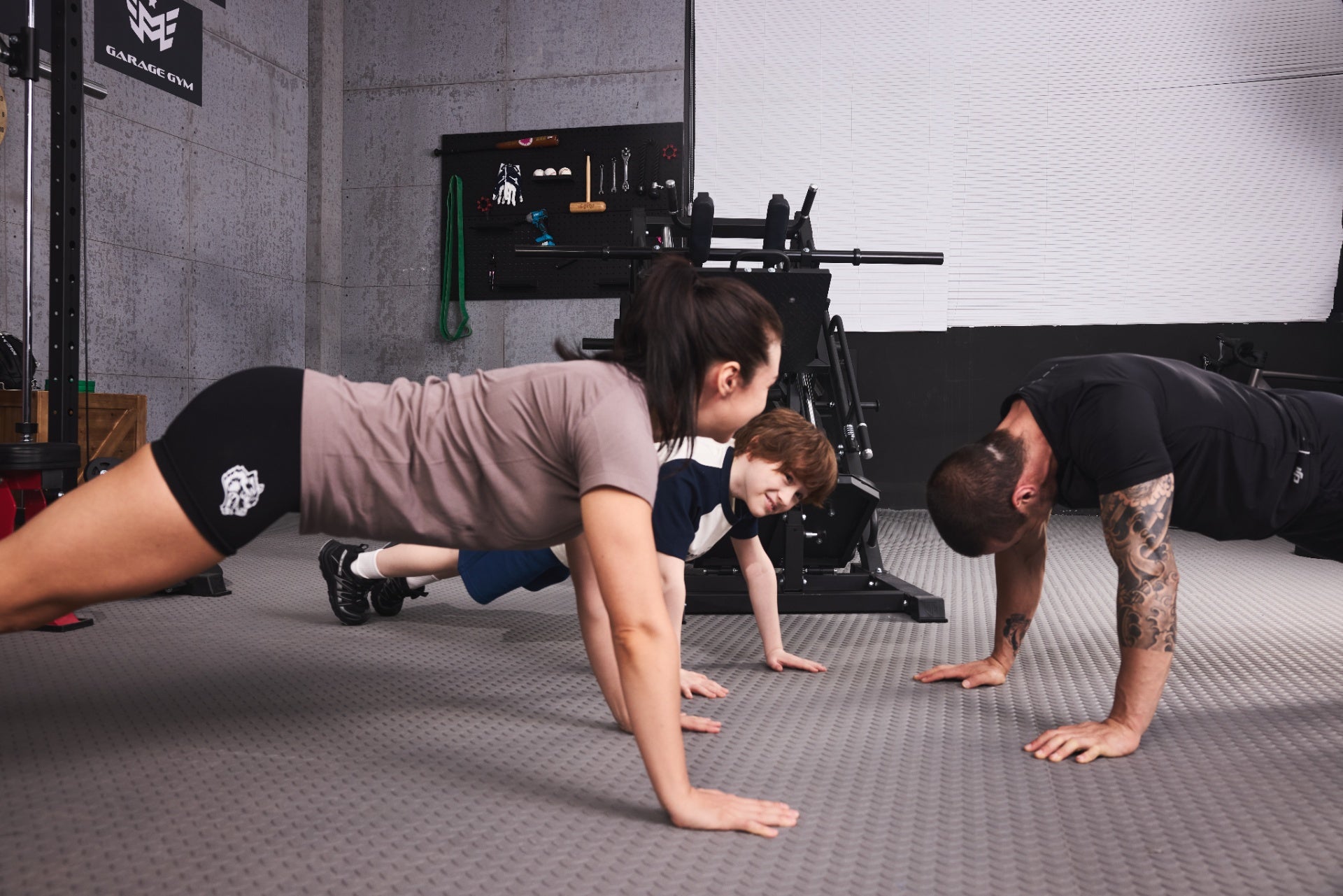  parents and child exercising together in home gym