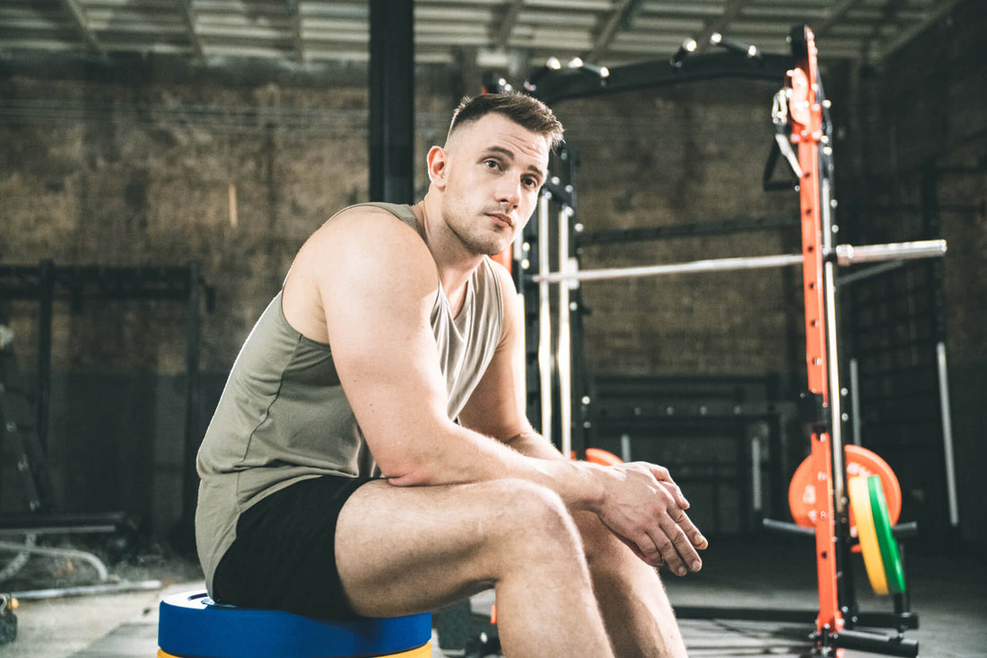  Individual taking a rest in a home gym with Major Lutie equipment in the background.