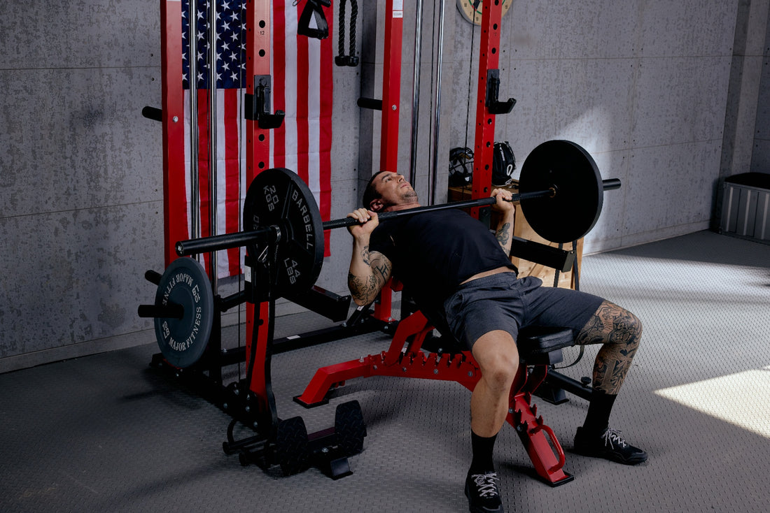 Man performing a flat bench press inside a power rack in a home gym.