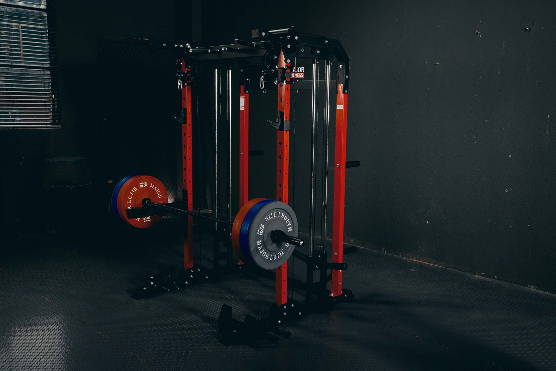 Power rack setup with barbell and weights in a home gym environment.