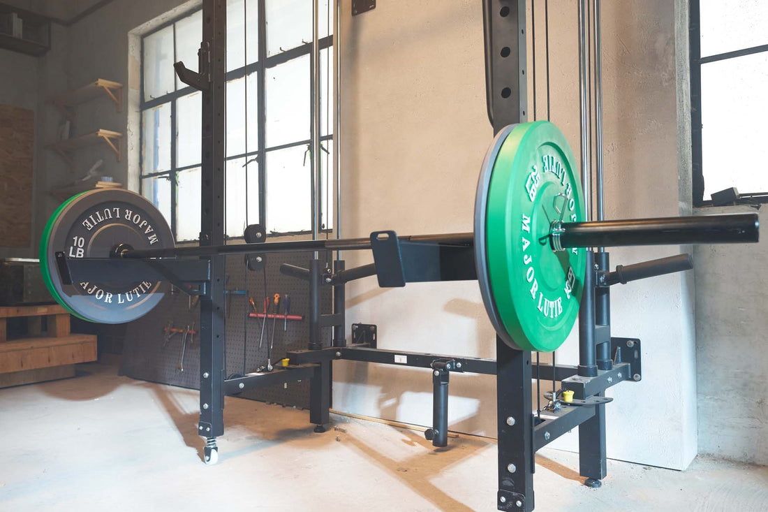 Power rack with a barbell and green weight plates in a home gym setup.