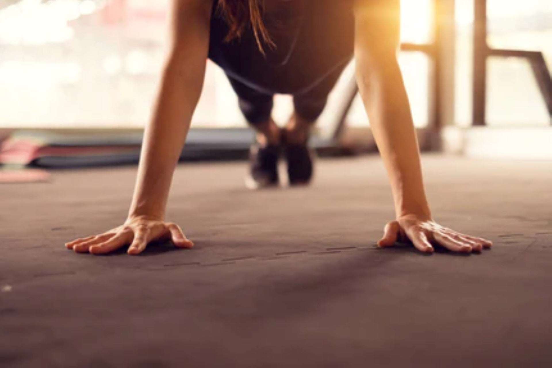 Person performing a push-up during a bodyweight exercise in a home gym setup.