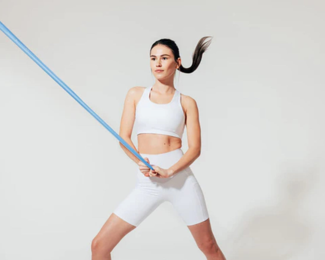 Woman engaging in fitness training with a resistance band at home.