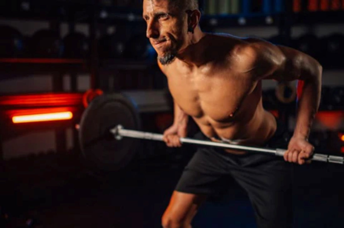 Man engaged in a barbell rowing exercise, focusing on strength training in a gym.