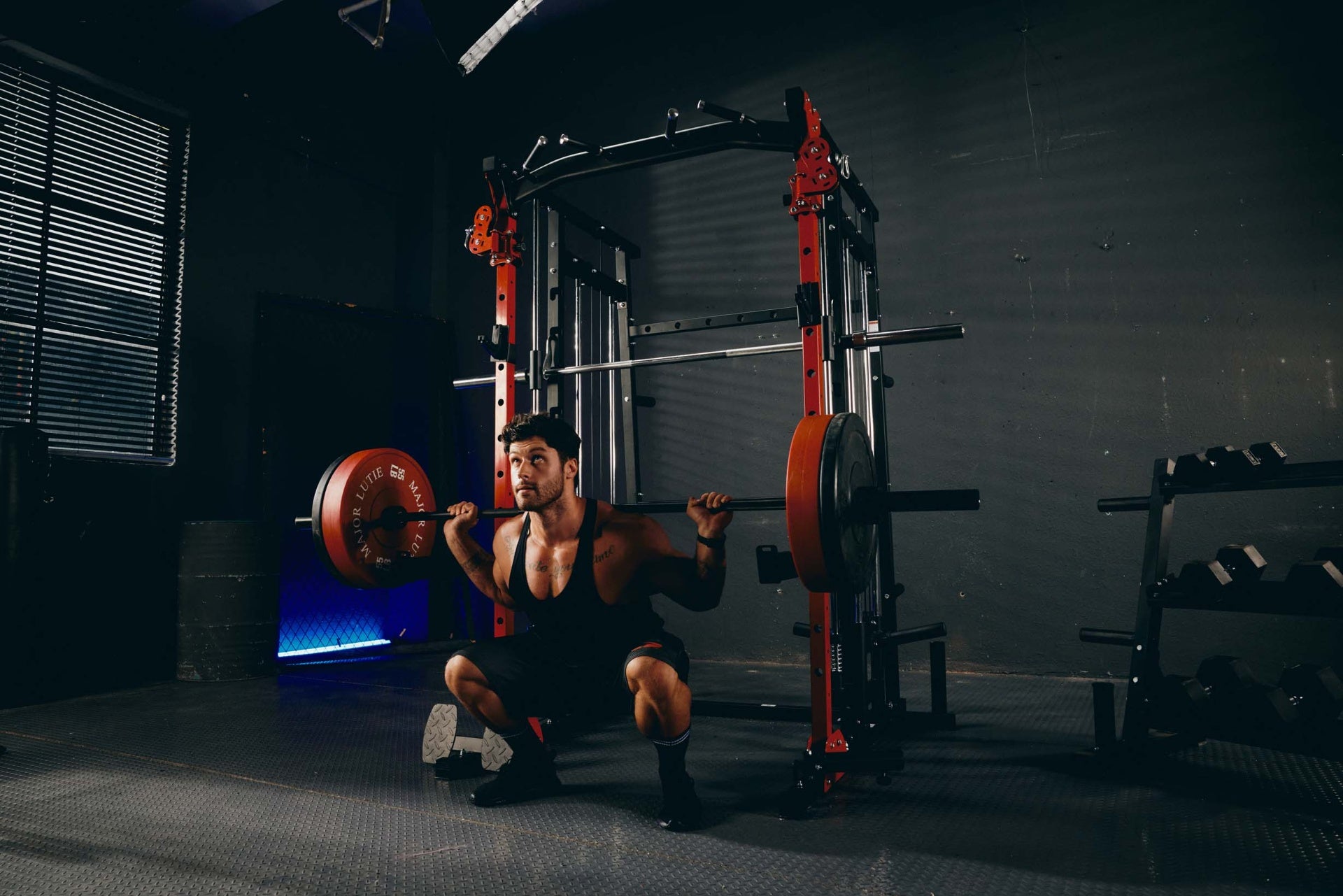 Man performing back squats with Smith machine in home gym.