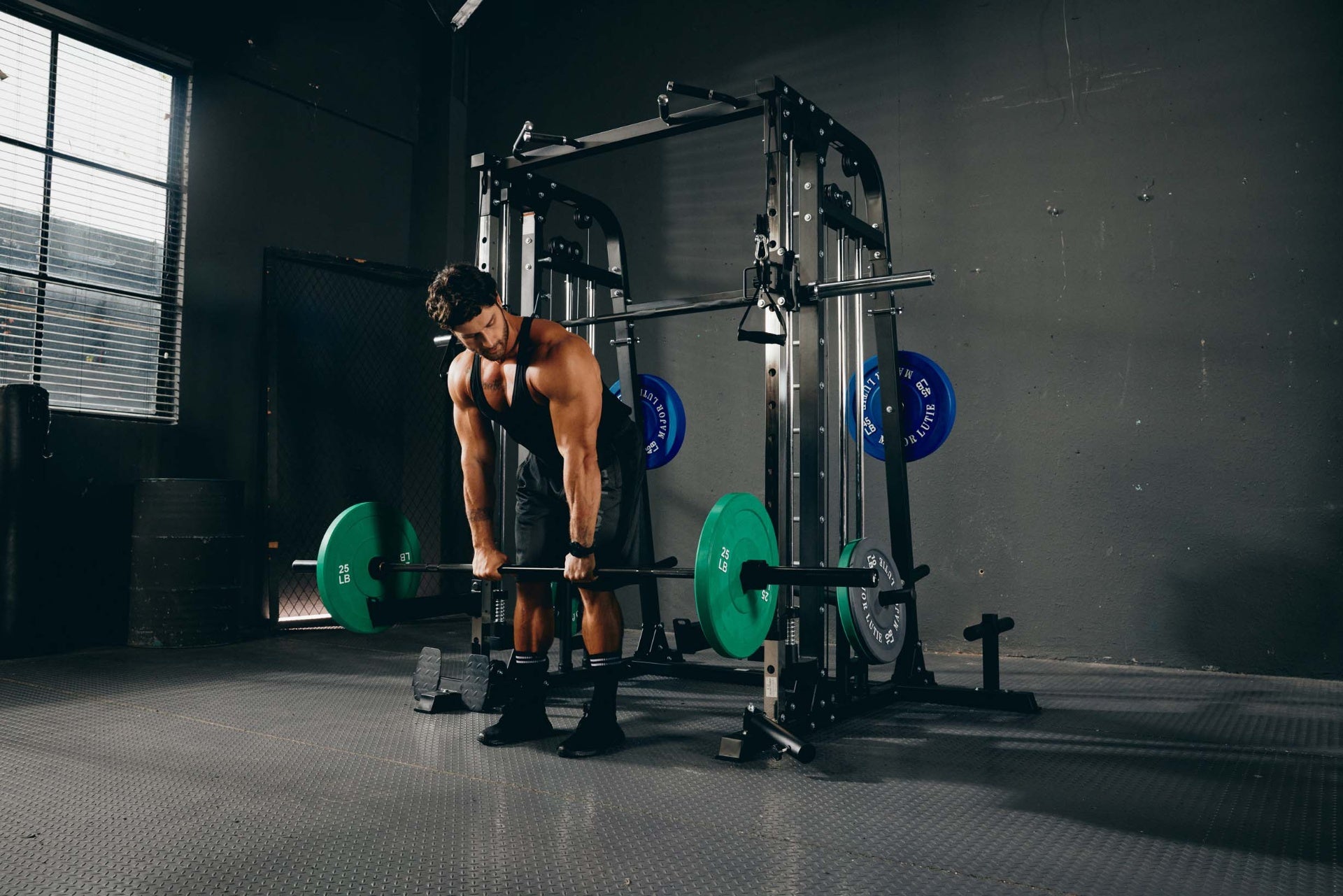 man performing a deadlift using a Smith machine in a home gym setting