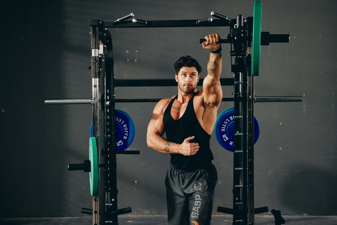 Man performing a pull-up exercise using a Smith machine.