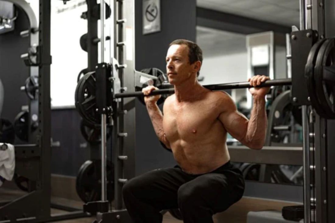 Man performing a squat on a Smith machine in a home gym setup.