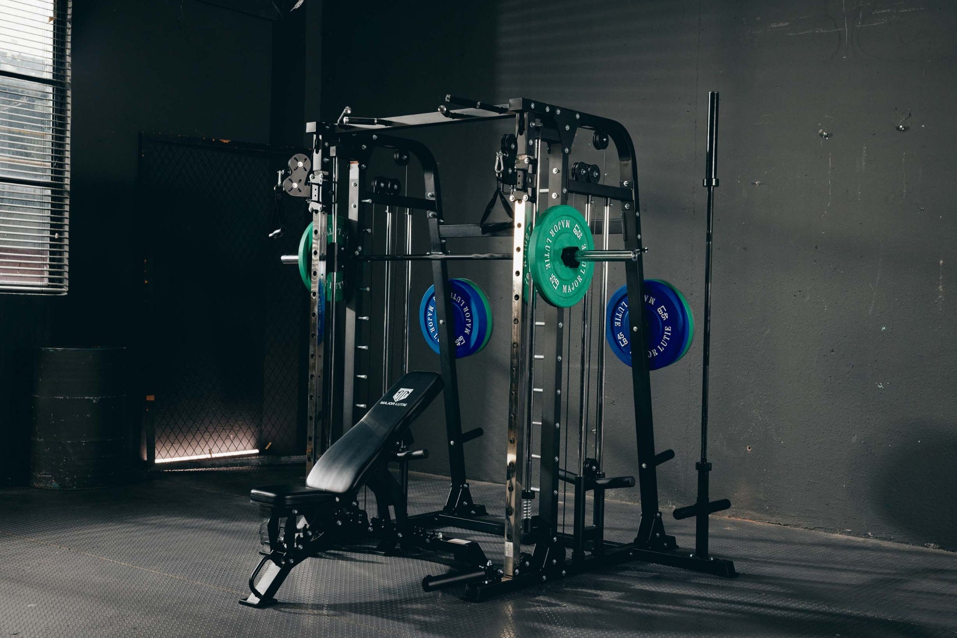 Home gym featuring a Smith machine with green and blue weight plates and an adjustable bench.