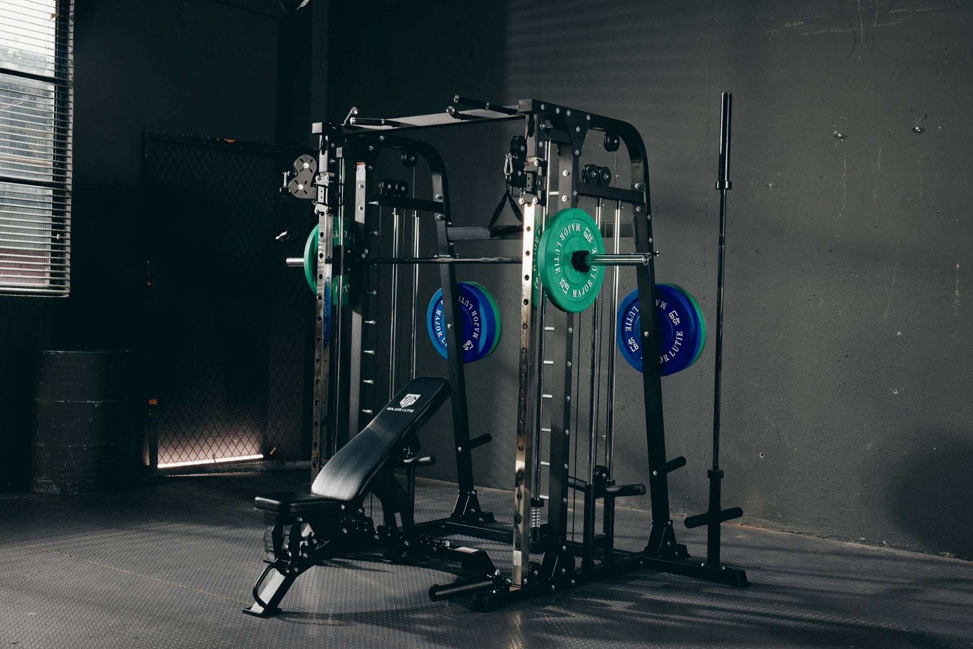 Home gym setup featuring a Smith machine with various weights and an adjustable bench.