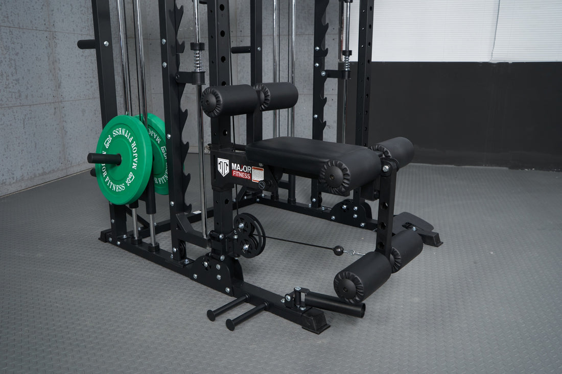 A Smith machine equipped with a leg extension attachment, placed in a home gym setup.