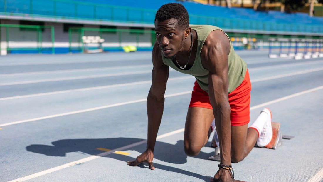 Sprinter positioned on starting blocks, ready for a race on the track.