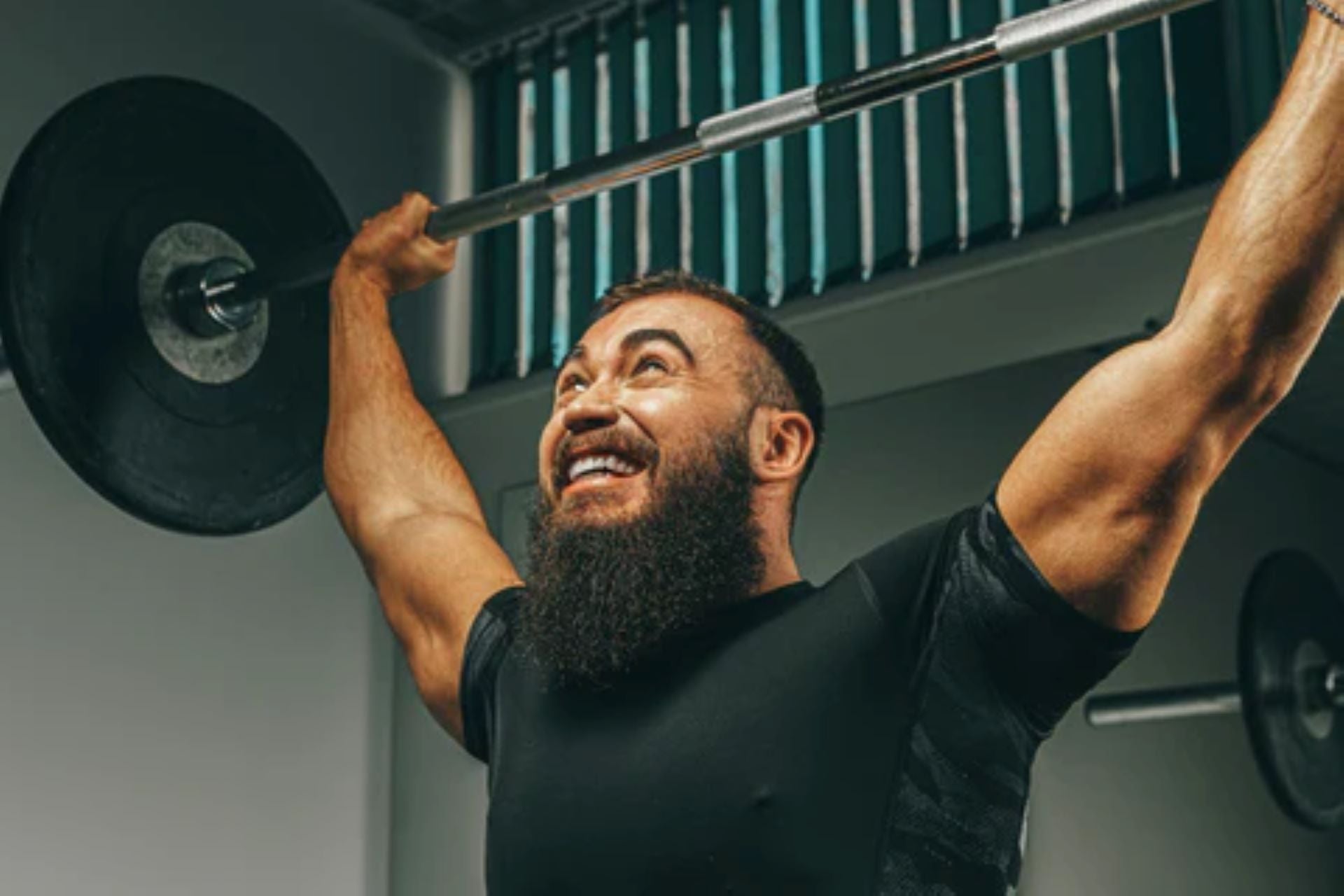 Man engaged in strength training with a barbell lift.