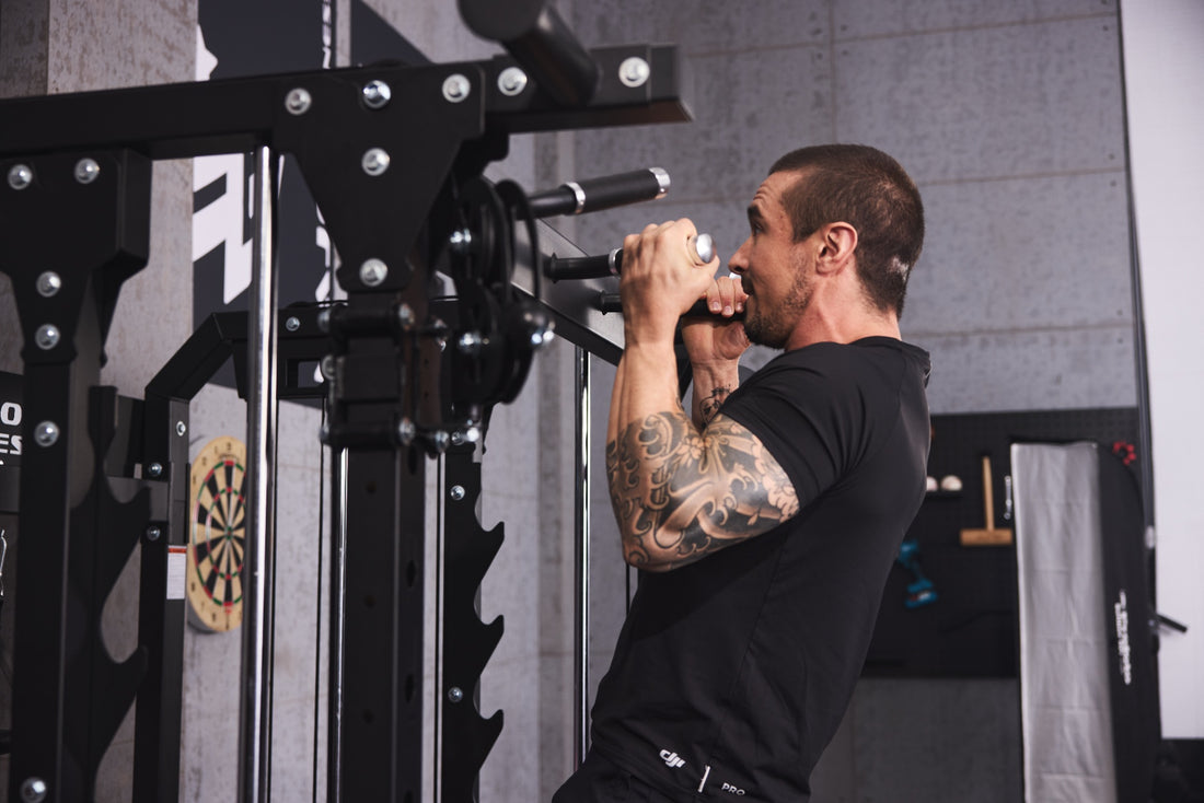 Shoulder press exercise using a Smith machine in a home gym.