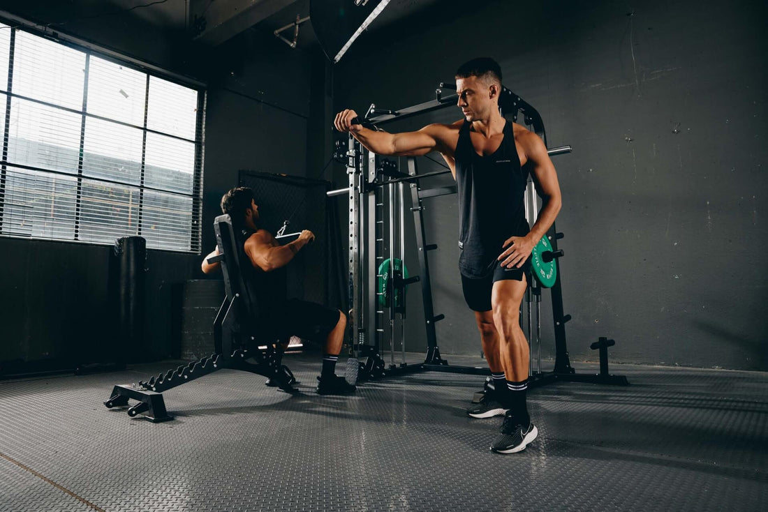 Two men performing strength training exercises on a Smith machine.