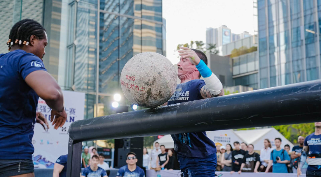 competitors lifting a heavy stone during the strongman competition at Strongest event