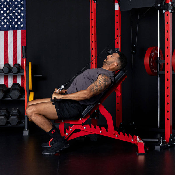 Man performing cable exercise on a Major Fitness weight bench in a home gym setup. 
